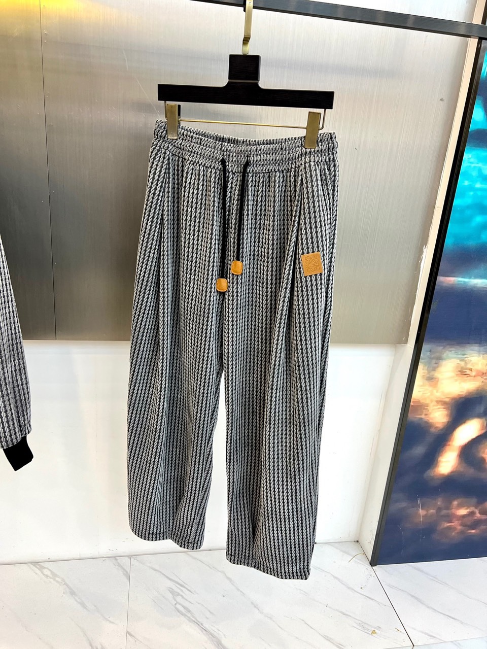 罗意威（LOEWE）套装，以经典的黑白千鸟格纹贯穿始终，将复古优雅与现代时尚感精妙结合。连帽上衣的千鸟格