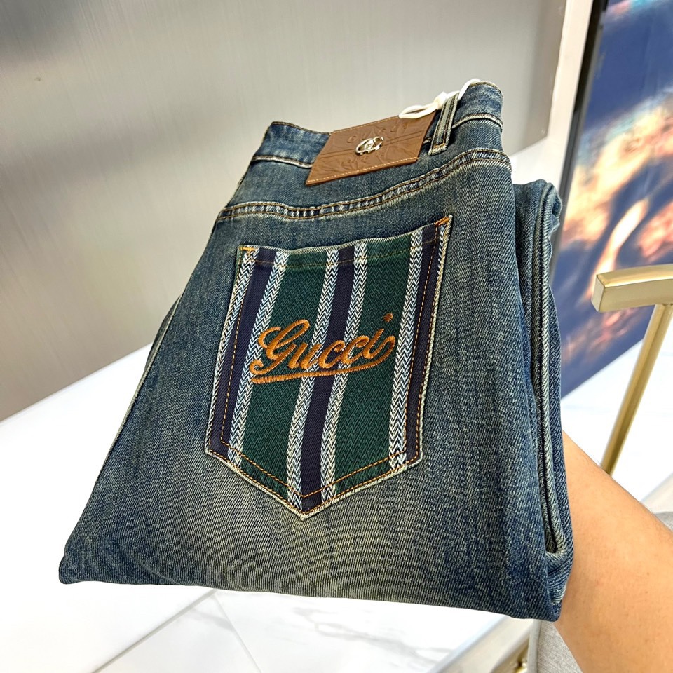 NO:681026,Gucci's new jeans for autumn and winter interpret the balance between retro and modernity with a classic straight silhouette. The style adopts a smooth straight cut, which naturally modifies the leg line and adapts to a variety of body shapes. The core highlight is the ingenious design of the back pocket. The right pocket is decorated with distinctive blue and green stripes and is embellished with gold Gucci letter embroidery, instantly becoming the visual focus; the left side is kept simple, forming a clever contrast. The classic leather label on the waist is branded with the double G logo, once again emphasizing the brand gene.  Its style is a fusion of luxury streetwear and retro aesthetics. The iconic embroidery and distressed wash effect give the item an uninhibited personality and sense of story. It can be easily paired with a simple white T-shirt and sneakers for a casual everyday look; it can also be combined with a personalized top and boots to create a highly recognizable trend.  Style. This pair of jeans is not only a versatile basic style in the wardrobe, but also a statement piece that shows a unique fashion attitude and Gucci-style luxury spirit. 29-36 (no 35),,gucci,gucci,boots,sneakers,jeans,19860909Gucc古驰、秋冬新品牛仔裤,以经典直筒廓形诠释复古与现代的平衡.款式采用流畅的直筒剪裁,自然修饰腿部线条,适配多元身形.核心亮点在于后袋的匠心设计右侧口袋饰以鲜明的蓝绿相间条纹,并点缀金色Gucci字母刺绣,瞬间成为视觉焦点；左侧则保持简约,形成巧妙对比.腰间的经典皮质标牌烙印双G标识,再次强调品牌基因. 其风格是奢华街头与复古美学的融合.标志性刺绣与做旧洗水效果,赋予单品不羁的个性与故事感.它能轻松搭配简约白T与运动鞋,演绎随性日常；亦可与个性上衣及短靴组合,打造极具辨识度的潮流造型.这条牛仔裤不仅是衣橱中的百搭基础款,更是彰显独特时尚态度与古驰式奢华精神的宣言单品.29-36（无35）,,gucci,gucci,boots,sneakers,jeans,,Men's clothing