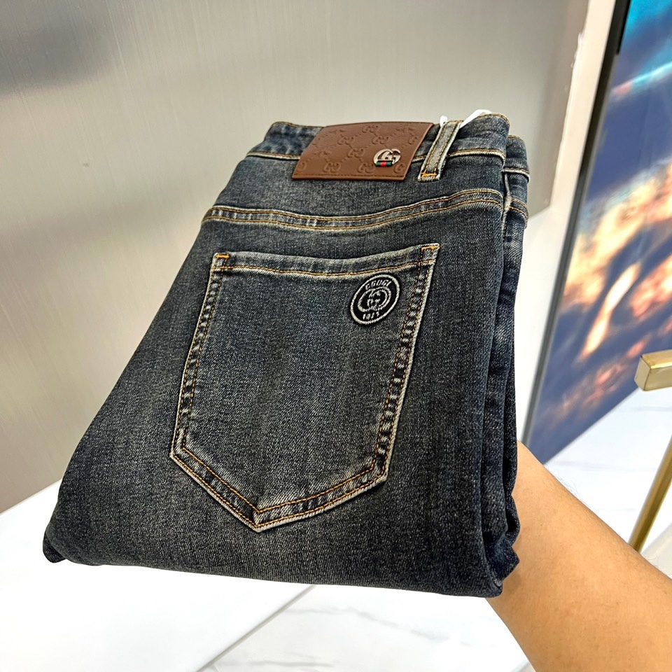 NO:681031,Gucci's new straight-leg jeans for autumn and winter reshape contemporary denim aesthetics. The style adopts a smooth straight cut, which fits the shape of the leg without losing its casualness. The iconic detail is that the back pocket is decorated with a delicate round metal logo, engraved with the brand logo, echoing the brown retro leather patch on the waist and Double G metal buckle, showing luxurious craftsmanship. The fabric is made of dark blue denim with a unique wash effect.  Its style is a perfect fusion of retro charm and modern modernity. The calm tones collide with exquisite metal and leather details, which are suitable for daily casual matching, and can also be integrated into more fashionable styles to easily control multiple occasions. This pair of jeans is not only a must-have item in the wardrobe, but also a personality statement that shows unique taste and Gucci's classic genes. 29-36 (no 35),,gucci,gucci,jeans,19860909Gucc古驰、秋冬新品直筒牛仔裤,重塑当代丹宁美学.款式采用流畅的直筒剪裁,贴合腿型而不失随性.标志性细节在于后袋饰有精致的圆形金属标志,镌刻品牌标识,与腰头棕色复古皮牌及双G金属扣相呼应,尽显奢华工艺.面料选用质感深蓝色牛仔布,搭配别致的洗水效果. 其风格是复古韵味与现代摩登的完美融合.沉稳的色调与精致的金属、皮革细节碰撞,既适合日常休闲搭配,亦可融入更具时装感的造型,轻松驾驭多元场合.这条牛仔裤不仅是衣橱必备单品,更是彰显独特品味与古驰经典基因的个性宣言.29-36（无35）,,gucci,gucci,jeans,,Men's clothing