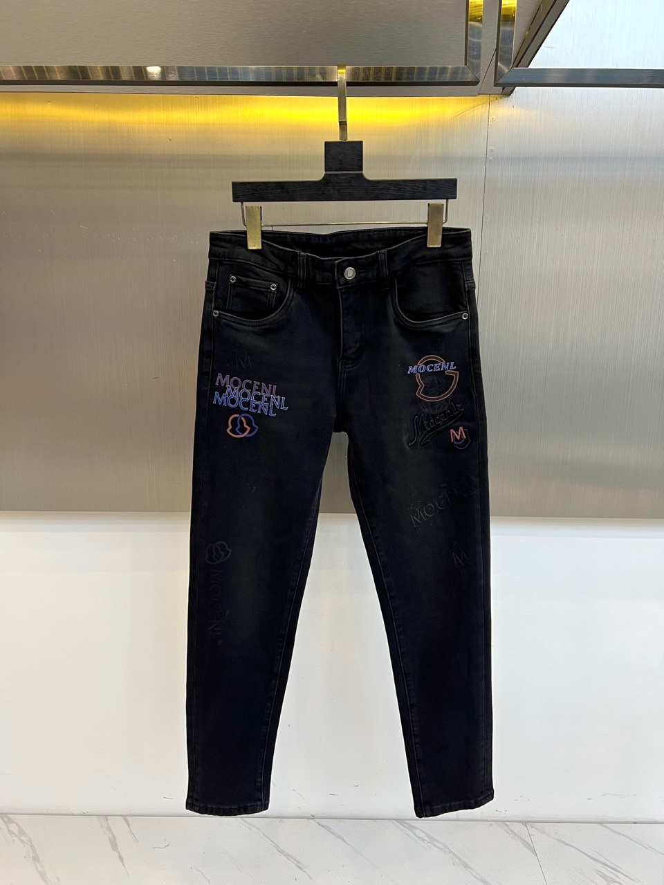 Mon蒙口、2025秋冬黑色牛仔裤，以经典五袋款式与精致细节诠释奢华日常。面料选用高品质深黑丹宁，触感扎
