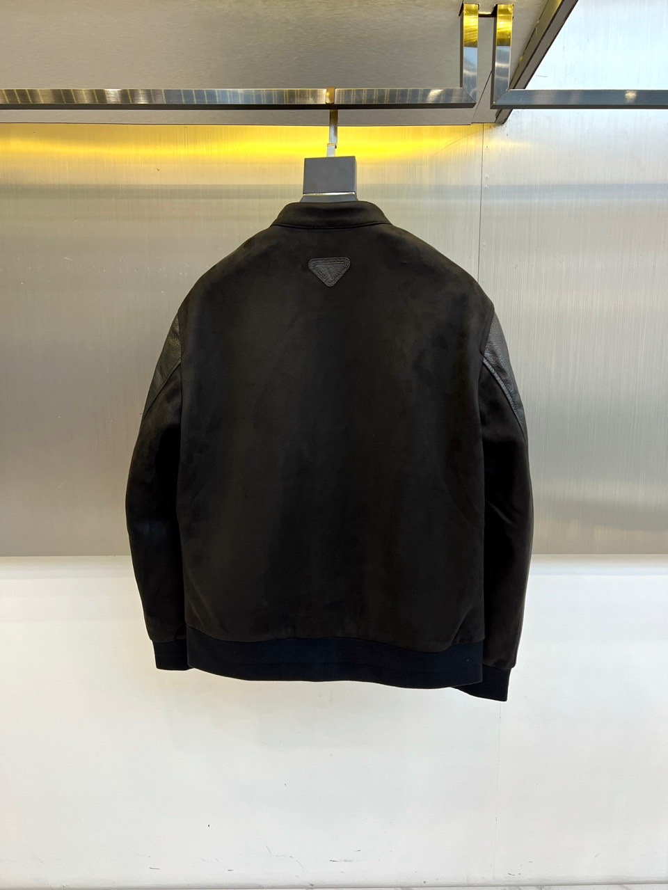 Prad普拉、2025秋冬新品 PRADA麂皮拼接夹克。这款夹克以复古摩登为设计基调，采用立领设计搭配金