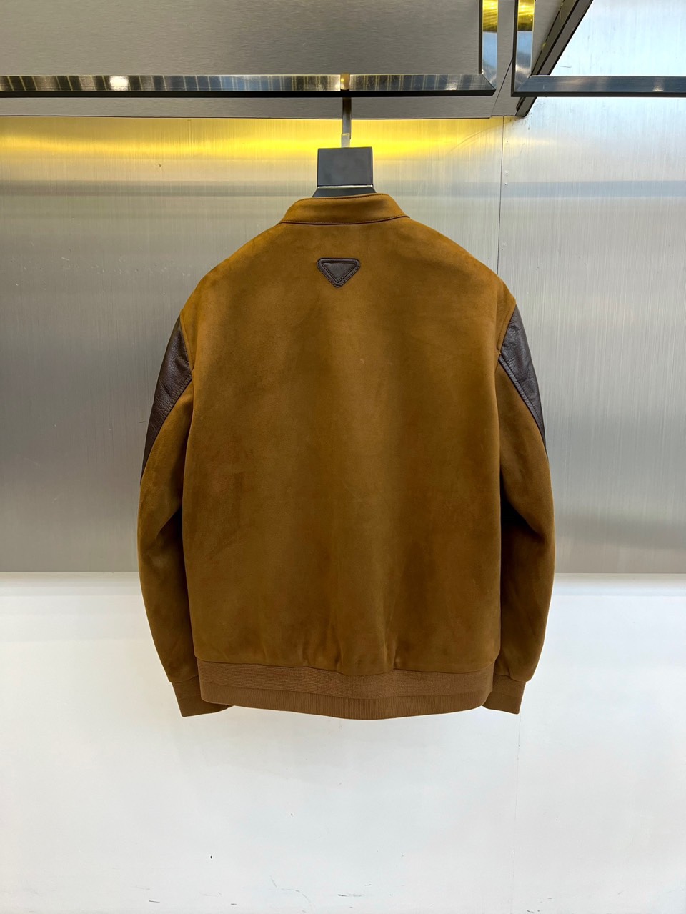 Prad普拉、2025秋冬新品 PRADA麂皮拼接夹克。这款夹克以复古摩登为设计基调，采用立领设计搭配金