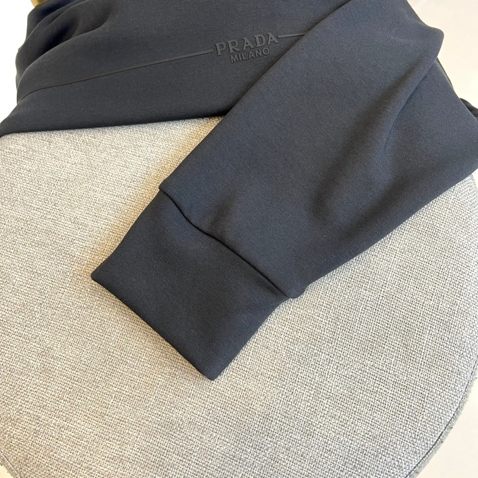 Prad普拉达、2025秋冬新品男士卫衣，以品牌标志性的极简美学重塑经典运动风格。本品采用320克莫代尔