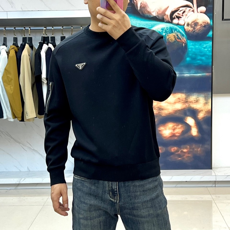 Prad普拉、2025秋冬新品 | PRADA极简卫衣。这款圆领卫衣采用微阔版型设计，左胸点缀品牌标志性