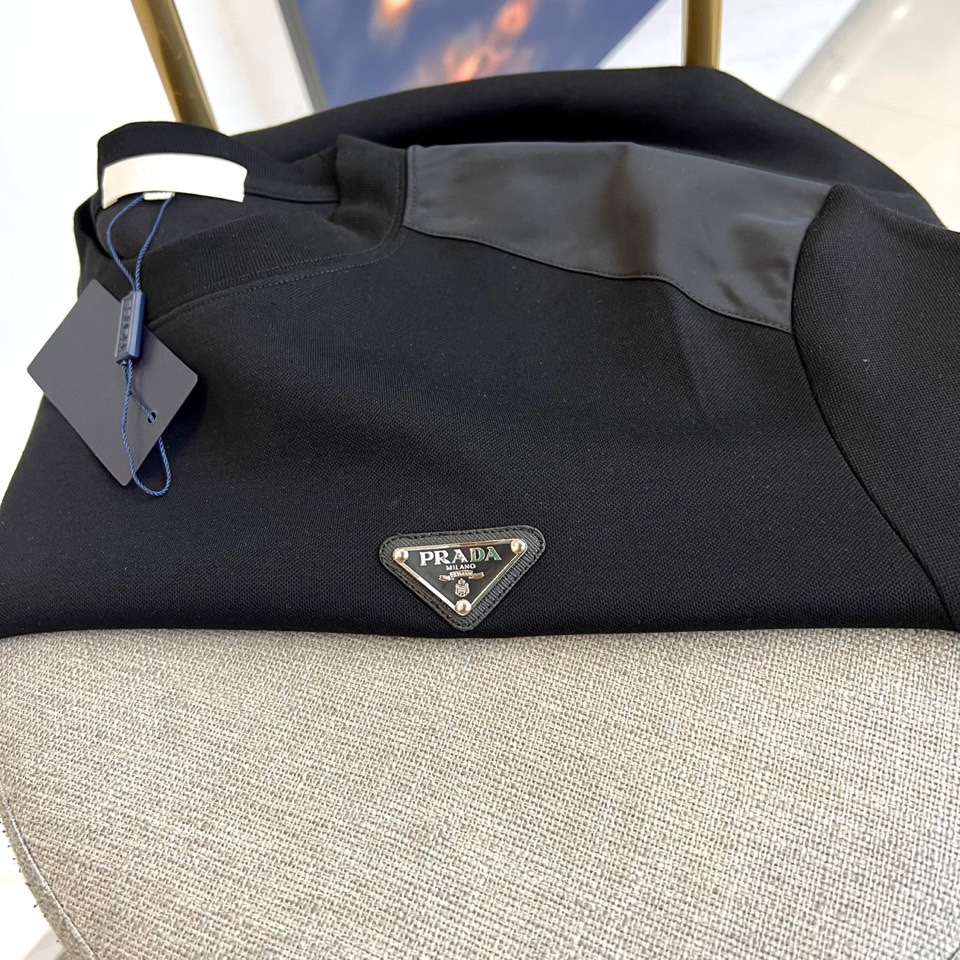 Prad普拉、2025秋冬新品 | PRADA极简卫衣。这款圆领卫衣采用微阔版型设计，左胸点缀品牌标志性