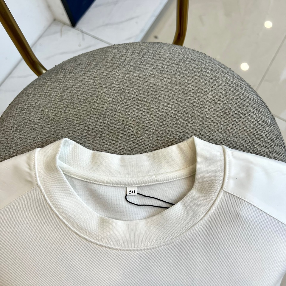 Prad普拉、2025秋冬新品 | PRADA极简卫衣。这款圆领卫衣采用微阔版型设计，左胸点缀品牌标志性