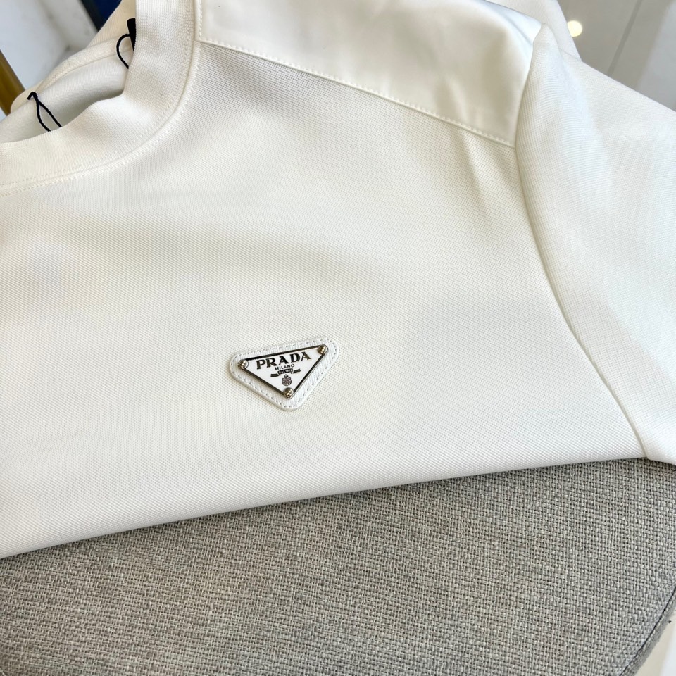 Prad普拉、2025秋冬新品 | PRADA极简卫衣。这款圆领卫衣采用微阔版型设计，左胸点缀品牌标志性