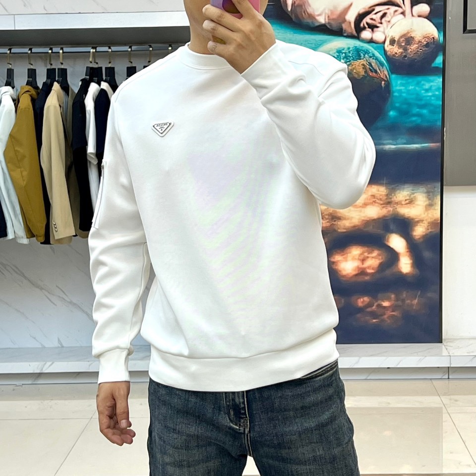 Prad普拉、2025秋冬新品 | PRADA极简卫衣。这款圆领卫衣采用微阔版型设计，左胸点缀品牌标志性