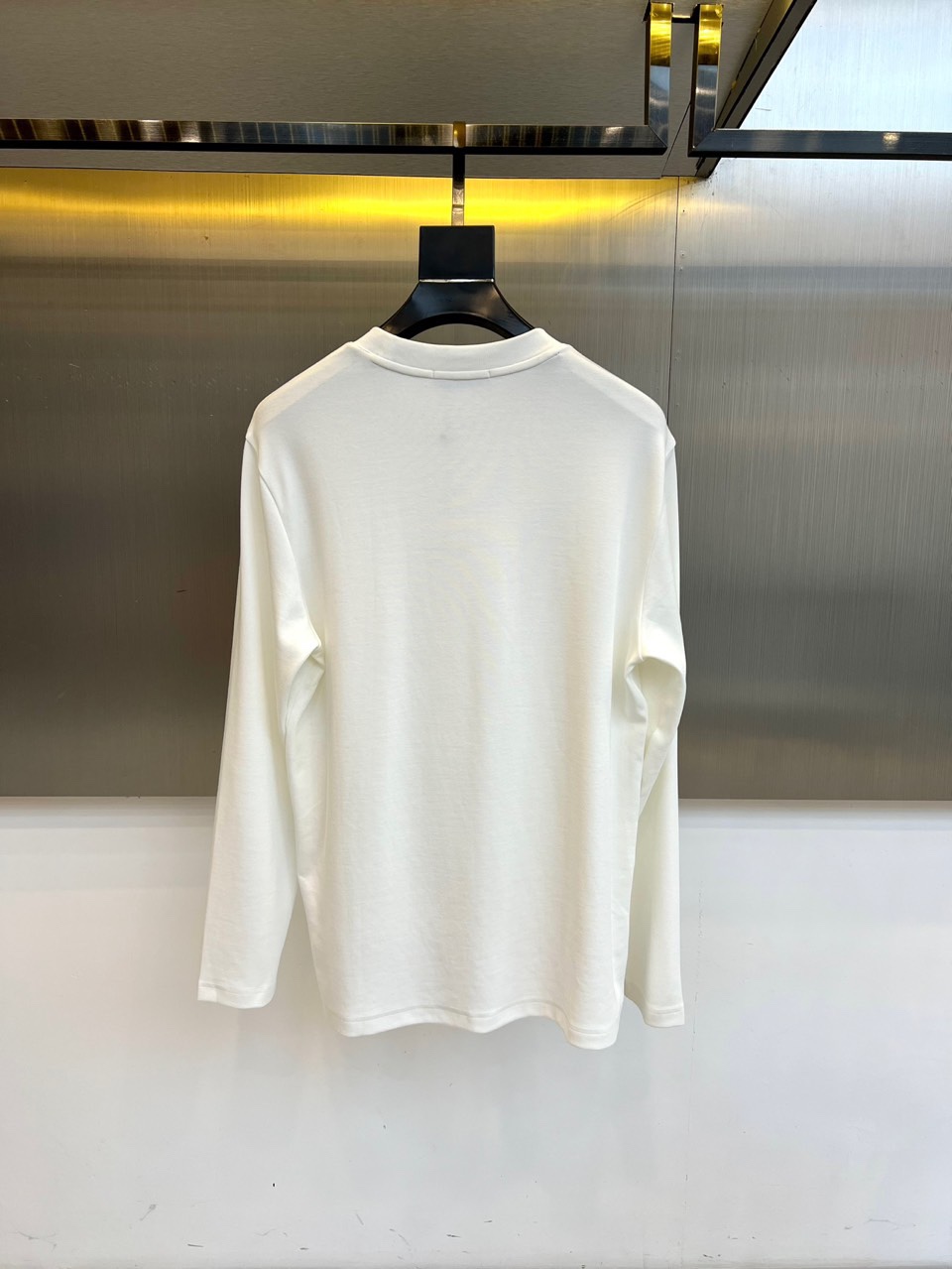 Mon蒙口、 2025秋冬新品长袖T恤，以极简设计诠释都市运动美学。款式采用经典圆领设计，领口融入品牌标