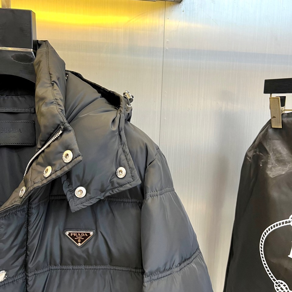 PRAD普拉（白鹅绒）、2025秋冬新作羽绒服，以标志性三角徽标续写意式奢华传奇。本系列推出深邃黑、军旅