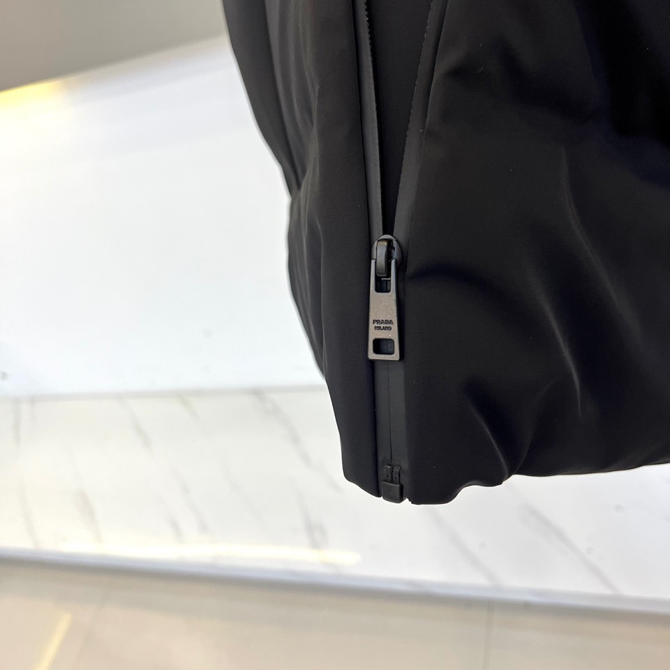 Prad普拉达、2025秋冬新品 PRADA机能风羽绒马甲。立领设计搭配无袖剪裁，正面配置黑色顺滑拉链开