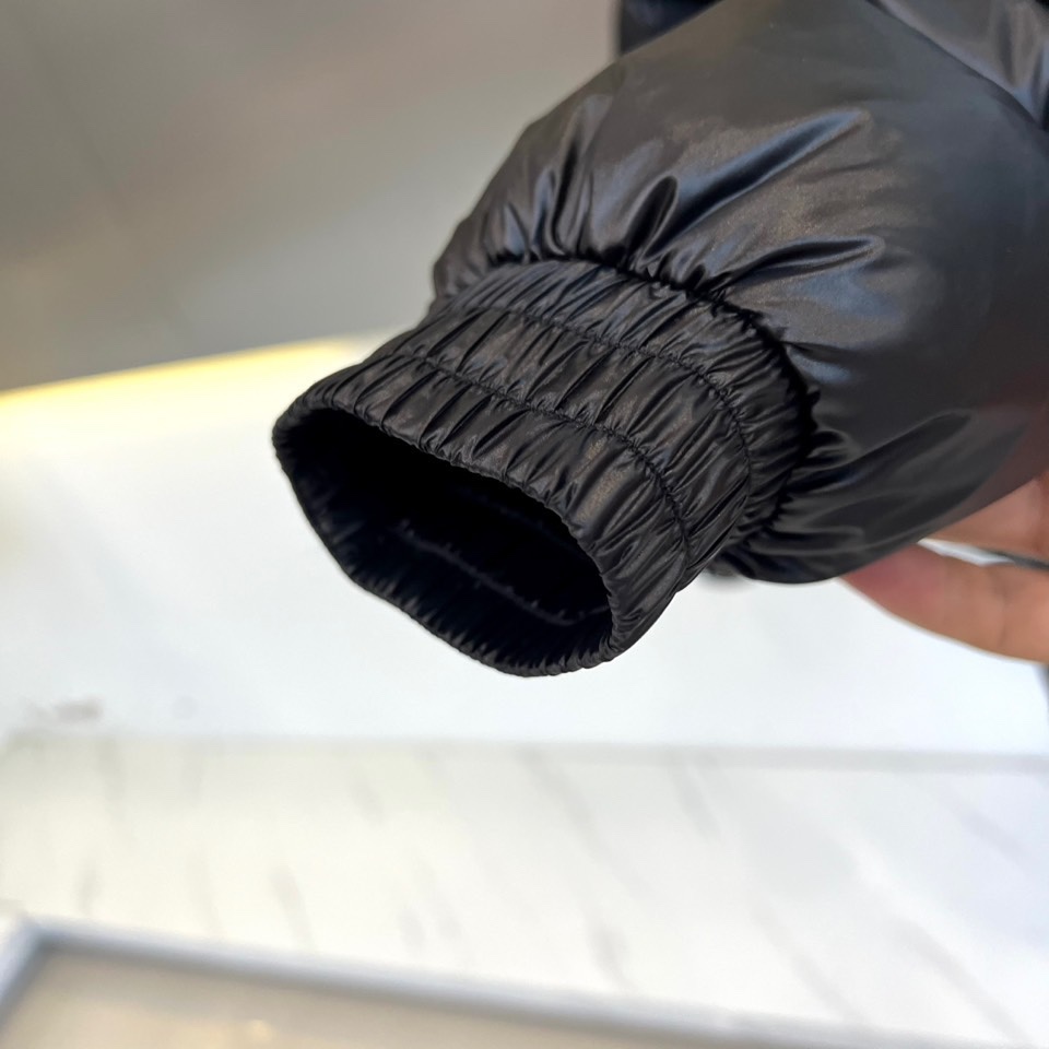 Prad普拉达、2025秋冬羽绒服，以极简美学重塑冬日防护。款式采用利落立领与流畅的箱型廓形，通过精准的