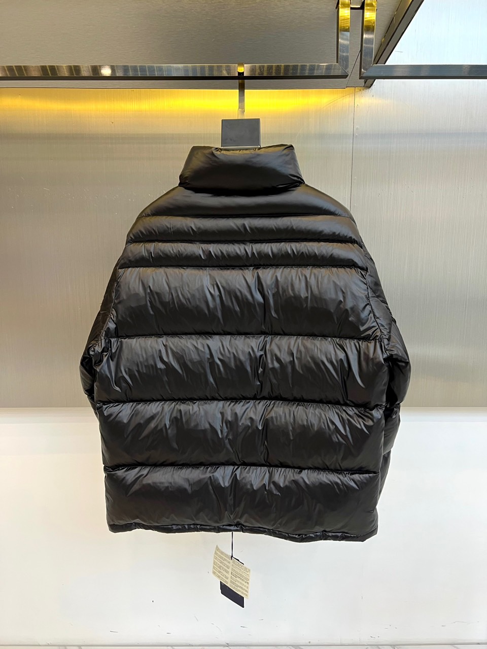 Prad普拉达、2025秋冬羽绒服，以极简美学重塑冬日防护。款式采用利落立领与流畅的箱型廓形，通过精准的