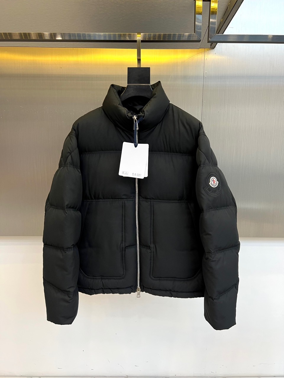 NO:681044,Mon (goose down), a new product for autumn and winter, redefines the high-end functional aesthetics of winter down jackets with an extremely simple black silhouette. The style adopts a neat stand-up collar design, with a smooth zipper, which outlines smooth lines. The exquisite pressed line partitions on the surface of the body not only stabilize the filling but also create a three-dimensional architectural layering. The iconic circular badge on the left sleeve low-key highlights the brand identity. The symmetrical pocket design on both sides cleverly combines beauty and practicality.  Its style is the perfect combination of modern urban feel and professional functions. Pure black and simple tailoring show a calm and powerful versatile temperament. The core quality comes from excellent filling, including 90% high-quality white goose down and 10% feathers, which strictly conforms to or even exceeds the United States (USA-) and Japan (JIS L1903).  2011) international standards, ensuring strong temperature locking and long-lasting bulkiness in extreme lightness. Whether paired with formal wear to create an urban elite image, or combined with casual wear to perform modern daily life, this down jacket can become a core item that enhances the overall texture and confidence. It is not only an equipment to withstand the cold, but also a winter investment that contains exquisite craftsmanship and reliable performance. 48-56 (model 173, 143 pounds, upper body size 50), Moncler, down jacket,19860909Mon蒙口（鹅绒）、秋冬新品,以极致简约的黑色廓形,重新定义冬日羽绒服的高级机能美学.款式采用利落的立领设计,搭配顺滑拉链,勾勒出流畅线条.衣身表面精致的压线分区,不仅稳固填充更塑造出立体的建筑层次感.左袖上标志性的圆形徽章,低调彰显品牌身份.两侧对称的口袋设计,巧妙融合美观与实用. 其风格是现代都市感与专业机能的完美结合.纯净的黑色与简洁剪裁,展现出冷静而强大的百搭气质.核心品质源自卓越填充内含90高品质白鹅绒与10羽毛,严格符合甚至超越美国（USA-）及日本（JIS L1903 2011）国际标准,确保在极致轻盈中提供强劲锁温与持久蓬松度.无论是搭配正装塑造都市精英形象,还是结合休闲服饰演绎摩登日常,这件羽绒服都能成为提升整体质感与自信的核心单品.它不仅是抵御严寒的装备,更是一件蕴含精湛工艺与可靠性能的冬日投资.48-56（模特173,143斤上身50码）,,Moncler,down jacket,,Men's clothing