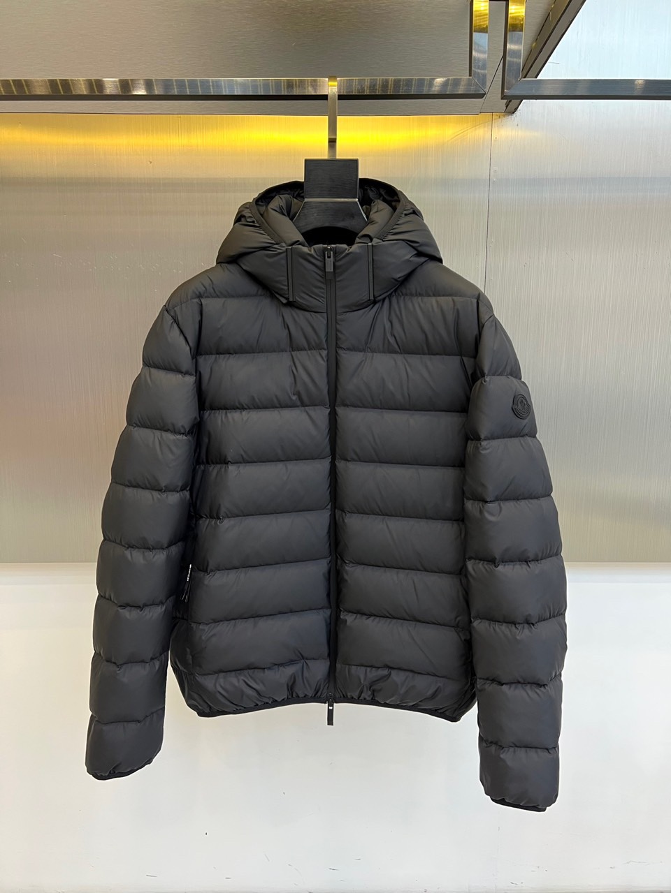 Mon蒙口、2025秋冬羽绒服，款式采用经典的连帽廓形，蓬松饱满的绗缝线条勾勒出立体的建筑感轮廓，有效锁
