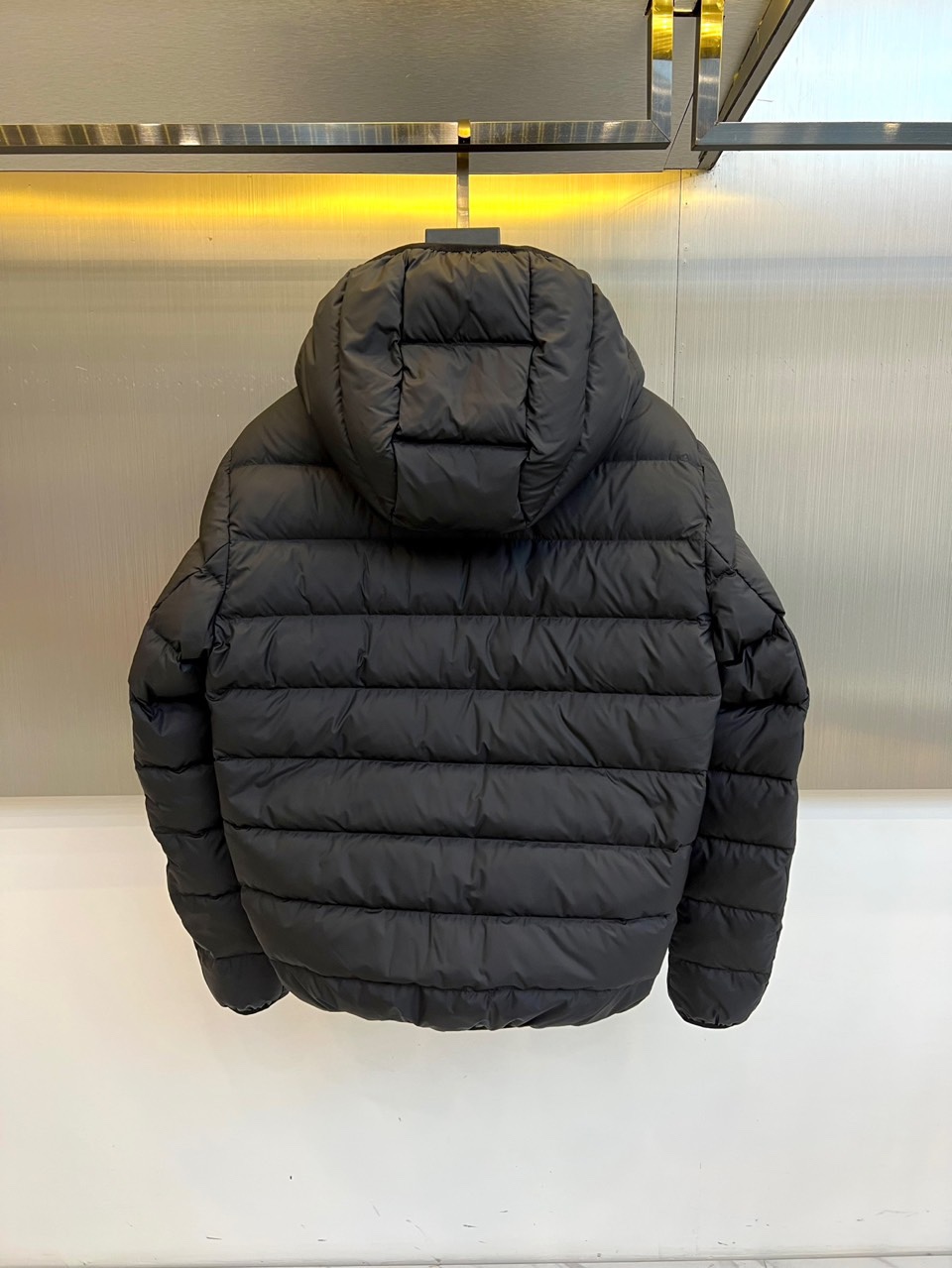 Mon蒙口、2025秋冬羽绒服，款式采用经典的连帽廓形，蓬松饱满的绗缝线条勾勒出立体的建筑感轮廓，有效锁