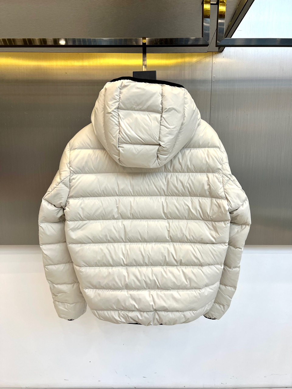 Mon蒙口、2025秋冬羽绒服，款式采用经典的连帽廓形，蓬松饱满的绗缝线条勾勒出立体的建筑感轮廓，有效锁