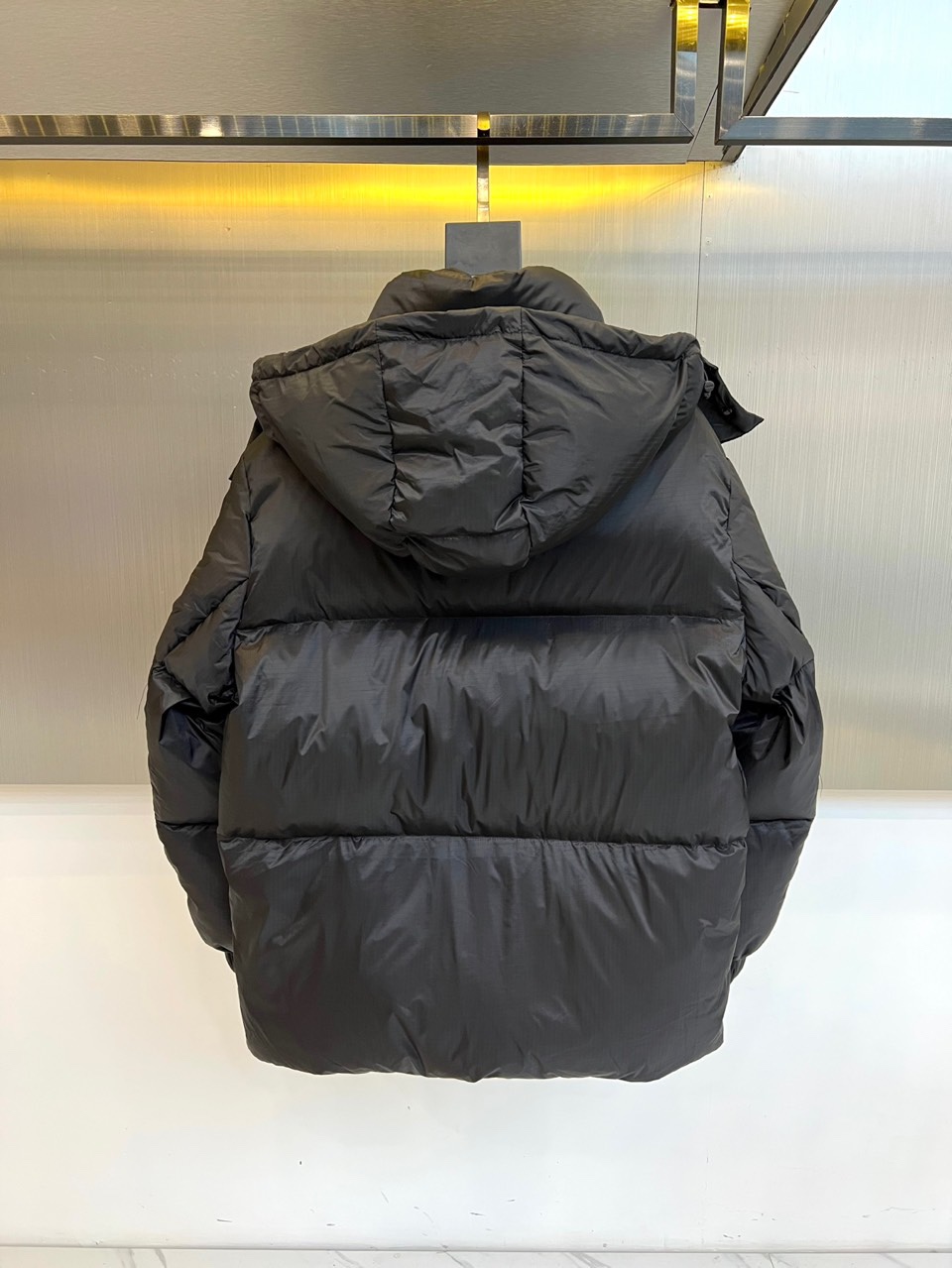 Prad普拉达、2025秋冬黑色羽绒服，以标志性设计语言重塑冬日温暖。款式采用宽松休闲的连帽廓形，帽檐配