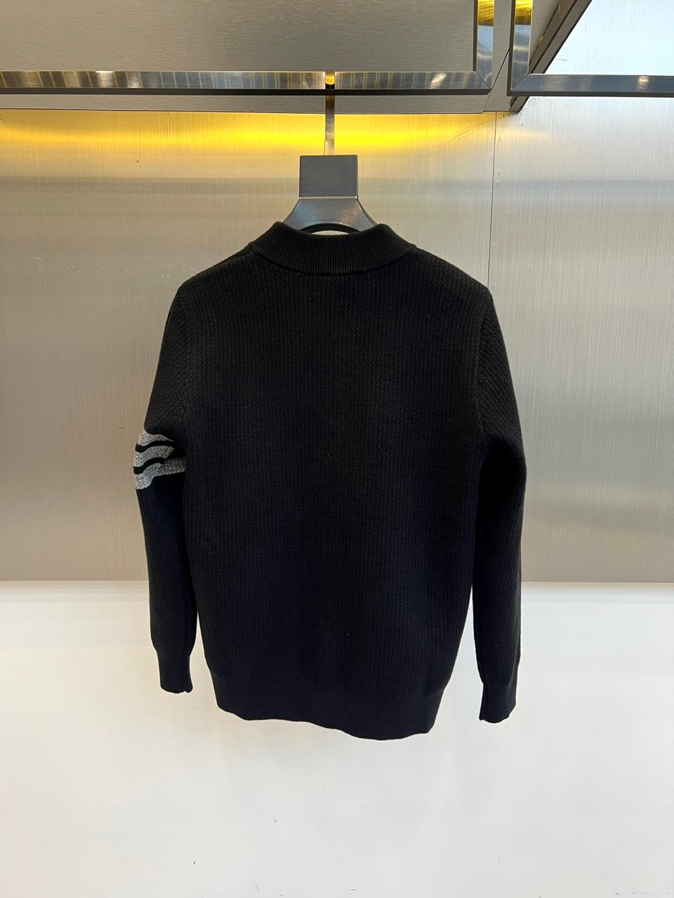 蒙口、2025秋冬新品以经典灰色针织开衫诠释休闲奢雅。标志性的棒球领设计，兼具利落与活力。前襟整齐排列的