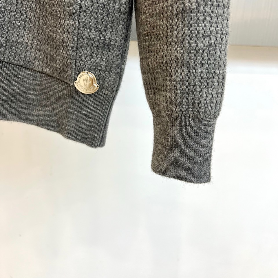 蒙口、2025秋冬新品以经典灰色针织开衫诠释休闲奢雅。标志性的棒球领设计，兼具利落与活力。前襟整齐排列的