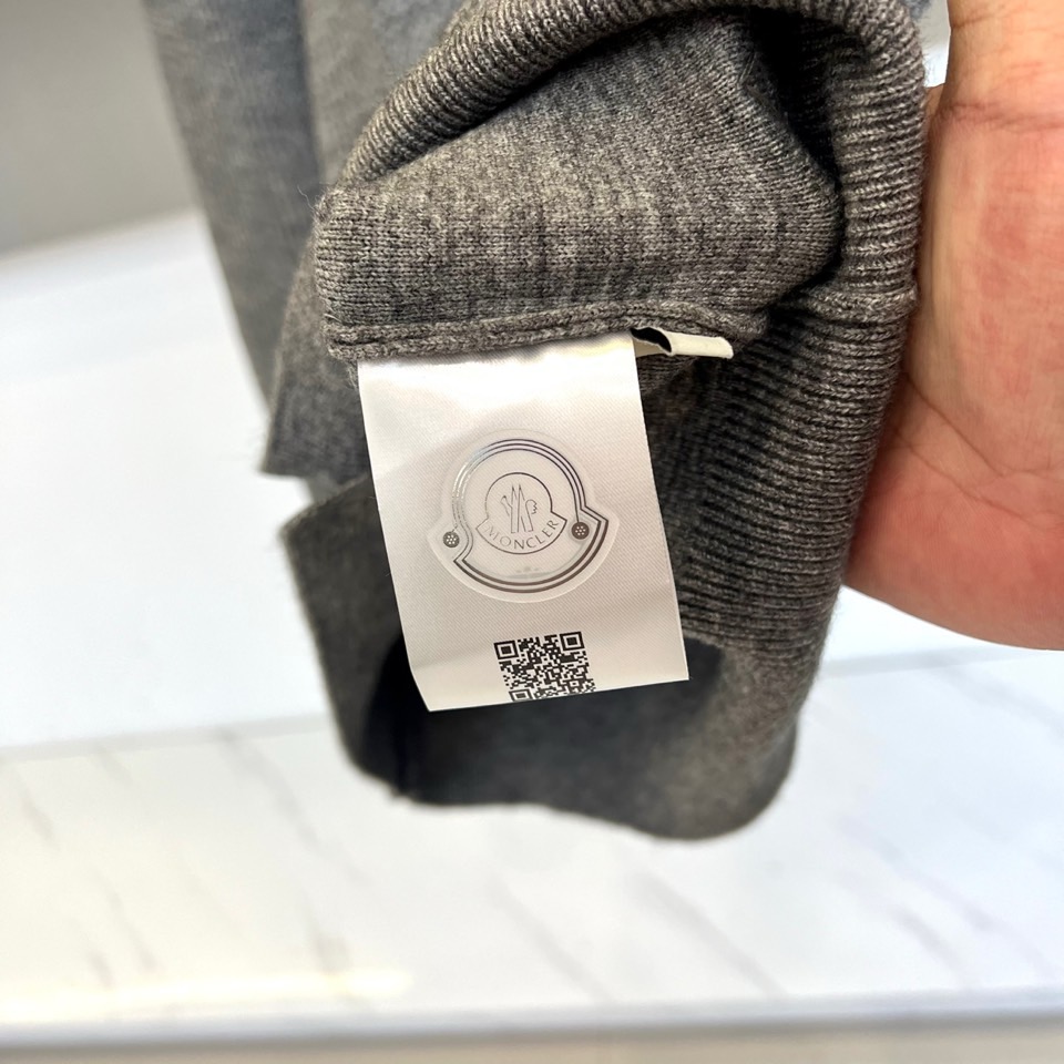 蒙口、2025秋冬新品以经典灰色针织开衫诠释休闲奢雅。标志性的棒球领设计，兼具利落与活力。前襟整齐排列的