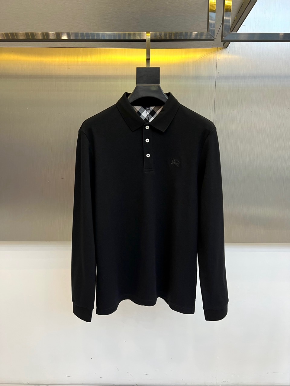 Bur巴宝莉、2025秋冬男士POLO衫以经典黑色演绎永恒英伦风度。标志性半开襟设计搭配三粒白色树脂纽扣