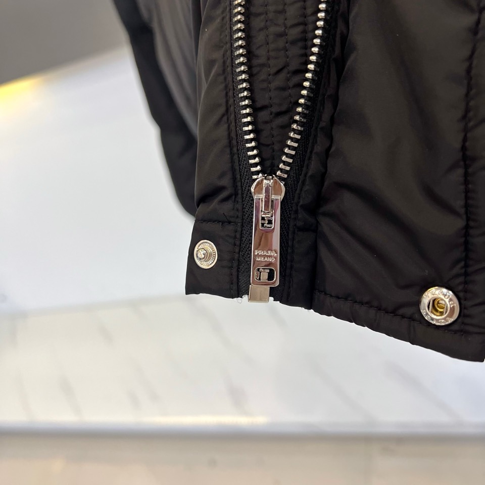 Prad普拉达、2025秋冬新品男士羽绒服，以深邃藏青色演绎现代都市的摩登型格。这件外套采用经典的箱型轮