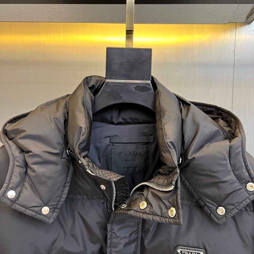 Prad普拉达、2025秋冬新品男士羽绒服，以深邃藏青色演绎现代都市的摩登型格。这件外套采用经典的箱型轮