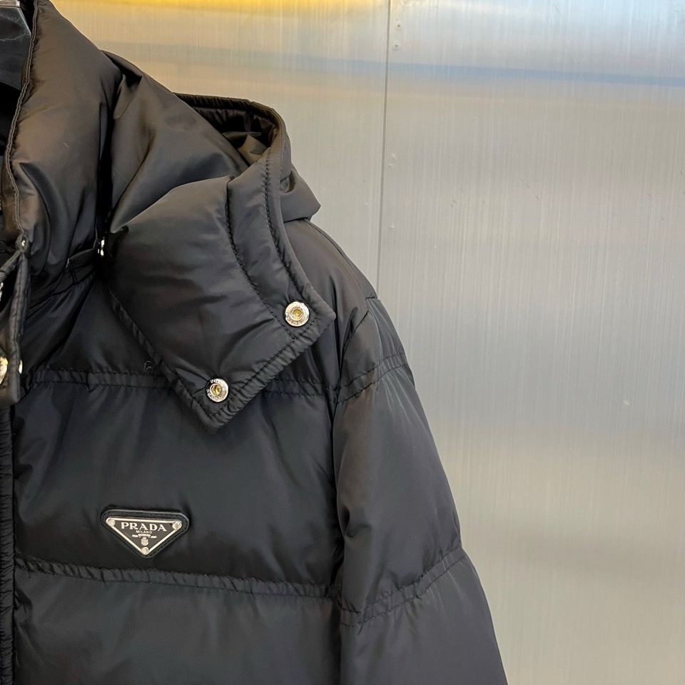 Prad普拉达、2025秋冬新品男士羽绒服，以深邃藏青色演绎现代都市的摩登型格。这件外套采用经典的箱型轮