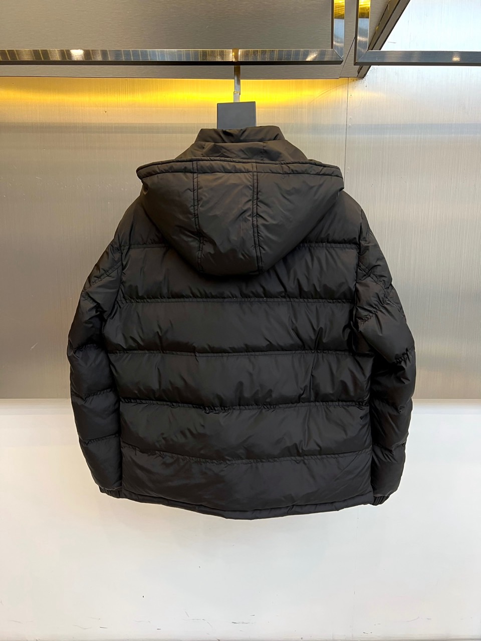 Prad普拉达、2025秋冬新品男士羽绒服，以深邃藏青色演绎现代都市的摩登型格。这件外套采用经典的箱型轮