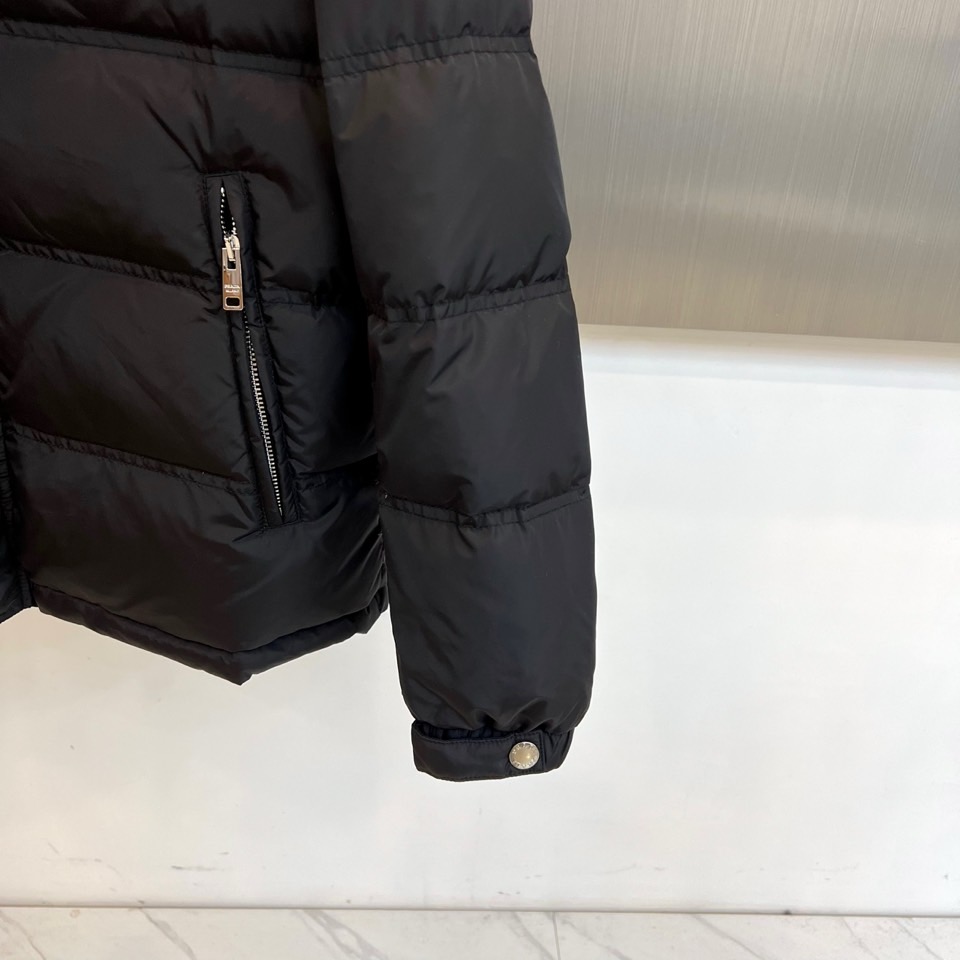 Prad普拉达、2025秋冬新品男士羽绒服，以深邃藏青色演绎现代都市的摩登型格。这件外套采用经典的箱型轮