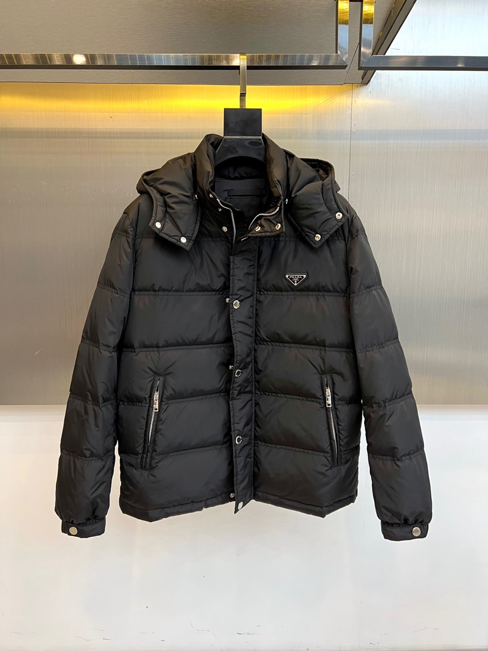 Prad普拉达、2025秋冬新品男士羽绒服，以深邃藏青色演绎现代都市的摩登型格。这件外套采用经典的箱型轮