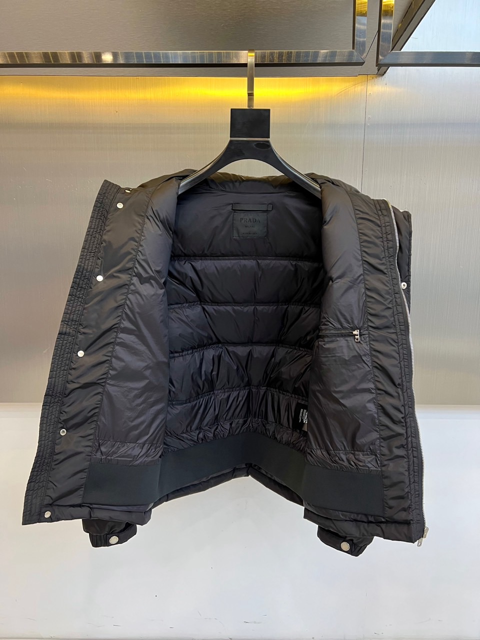 Prad普拉达、2025秋冬新品男士羽绒服，以深邃藏青色演绎现代都市的摩登型格。这件外套采用经典的箱型轮