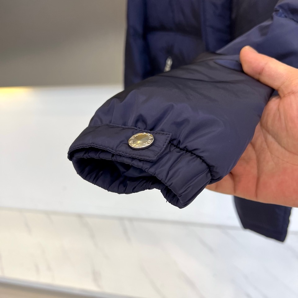 Prad普拉达、2025秋冬新品男士羽绒服，以深邃藏青色演绎现代都市的摩登型格。这件外套采用经典的箱型轮