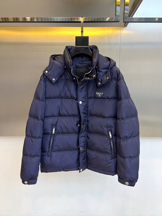 Prad普拉达、2025秋冬新品男士羽绒服，以深邃藏青色演绎现代都市的摩登型格。这件外套采用经典的箱型轮
