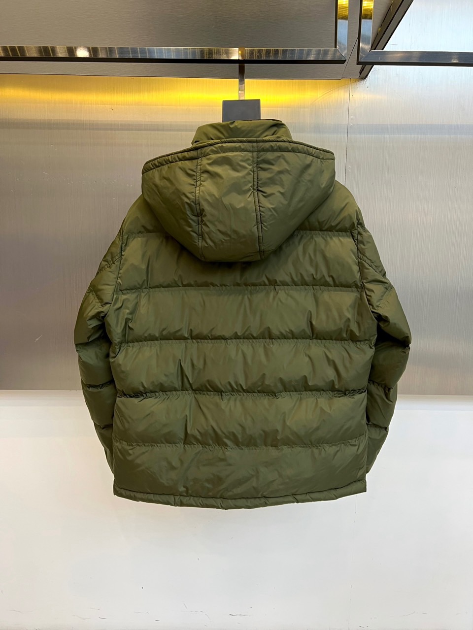 Prad普拉达、2025秋冬新品男士羽绒服，以深邃藏青色演绎现代都市的摩登型格。这件外套采用经典的箱型轮