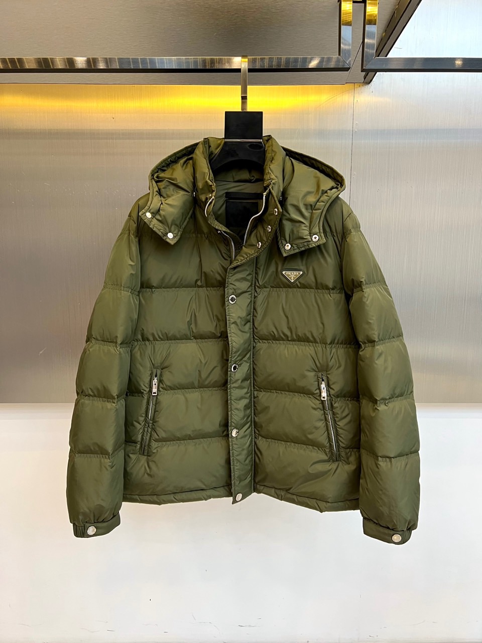 Prad普拉达、2025秋冬新品男士羽绒服，以深邃藏青色演绎现代都市的摩登型格。这件外套采用经典的箱型轮