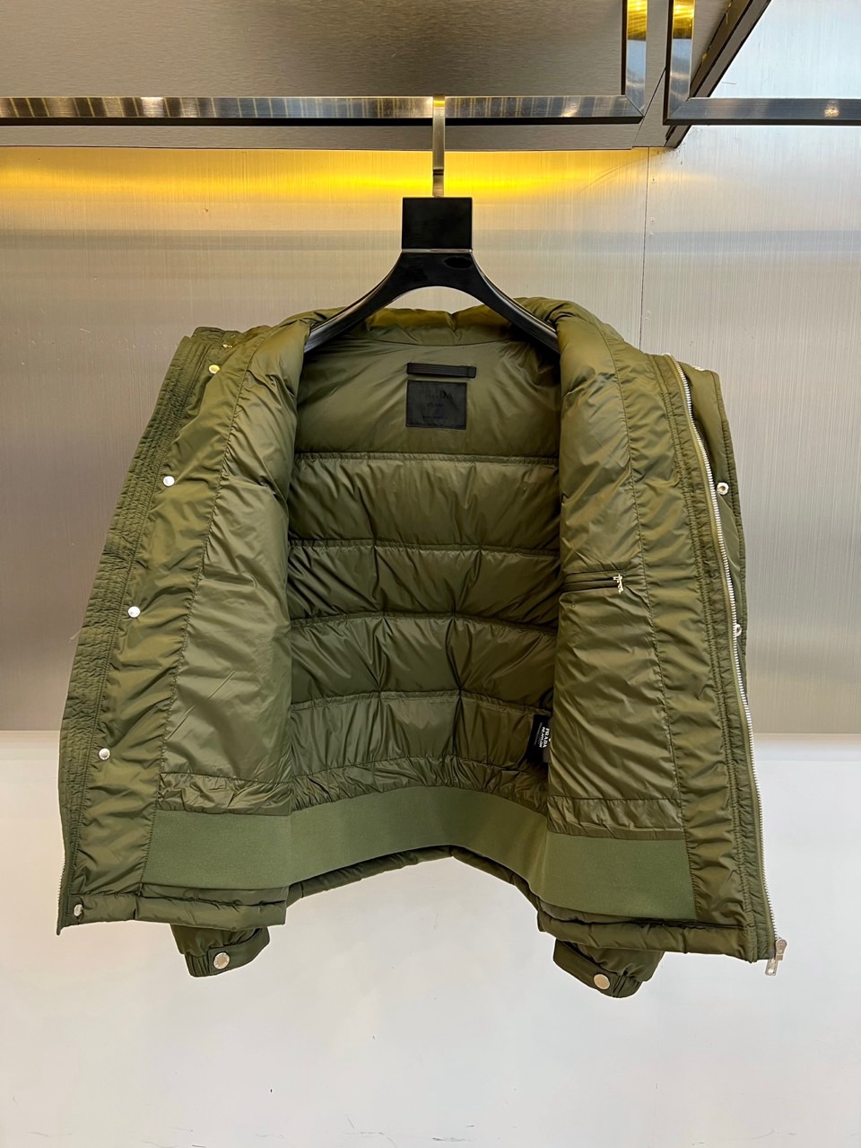 Prad普拉达、2025秋冬新品男士羽绒服，以深邃藏青色演绎现代都市的摩登型格。这件外套采用经典的箱型轮