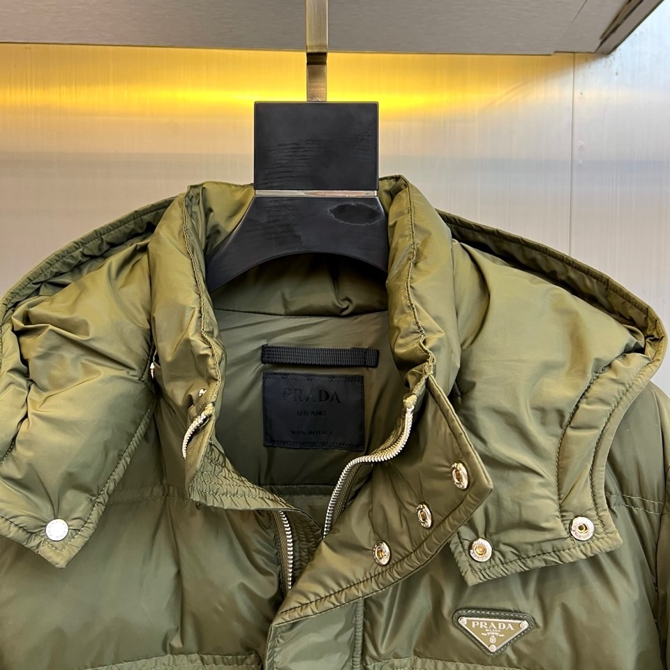 Prad普拉达、2025秋冬新品男士羽绒服，以深邃藏青色演绎现代都市的摩登型格。这件外套采用经典的箱型轮