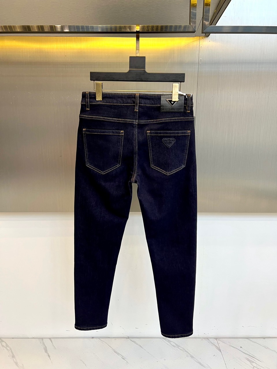 Prad普拉达、2025秋冬男士修身牛仔裤，选用深邃纯正靛蓝色丹宁面料，质感扎实挺括，结合利落的修身直筒
