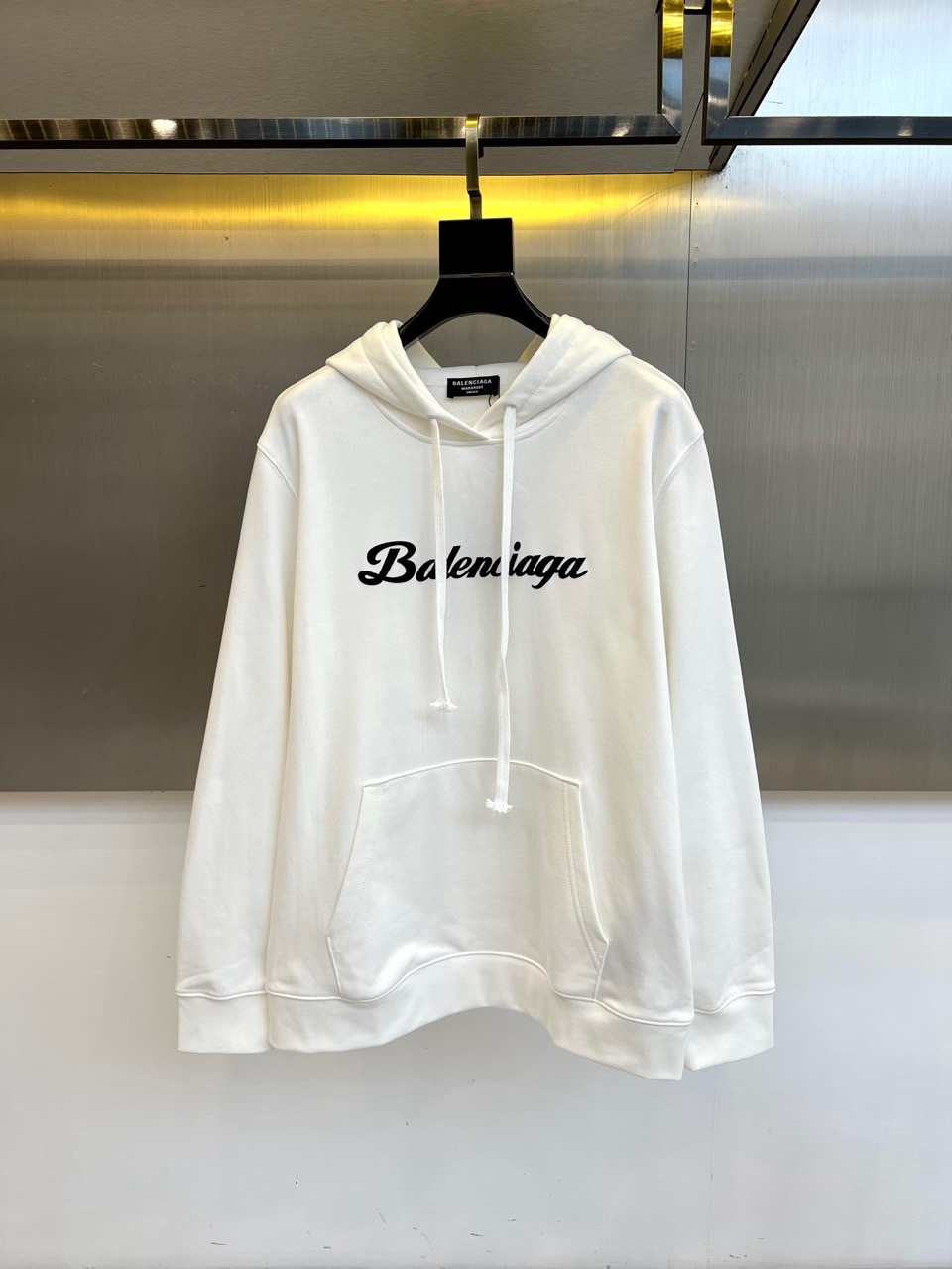 Ba巴黎世家、2025秋冬新品连帽套头卫衣，以纯白色基调彰显现代街头奢华风格。这款卫衣采用经典连帽设计搭