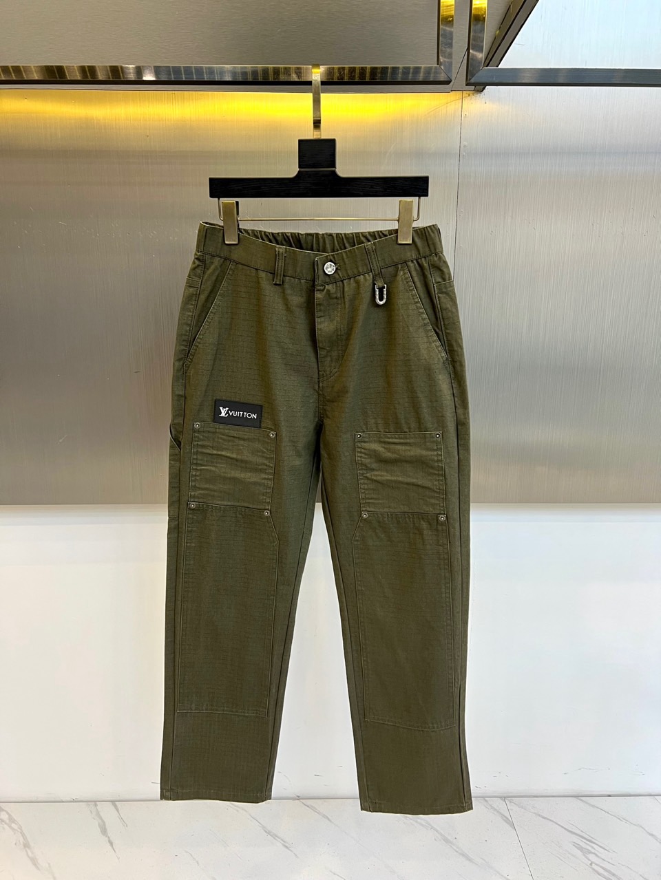 1v威登、2025秋冬男士系列，以军绿色宽松长裤诠释兼具实用与奢华的工装美学。款式采用宽松直筒廓形，确保