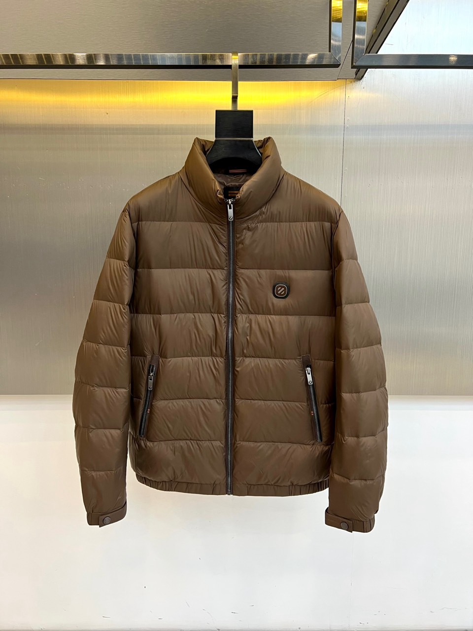 Zegna杰尼亚、2025秋冬男士羽绒服，以深邃棕色诠释经典与功能并存的高阶美学。款式采用利落的立领设计