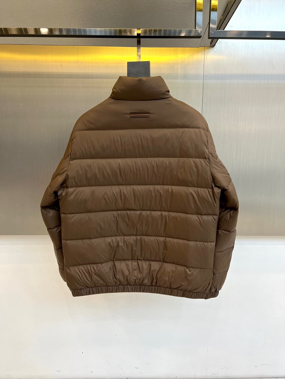 Zegna杰尼亚、2025秋冬男士羽绒服，以深邃棕色诠释经典与功能并存的高阶美学。款式采用利落的立领设计