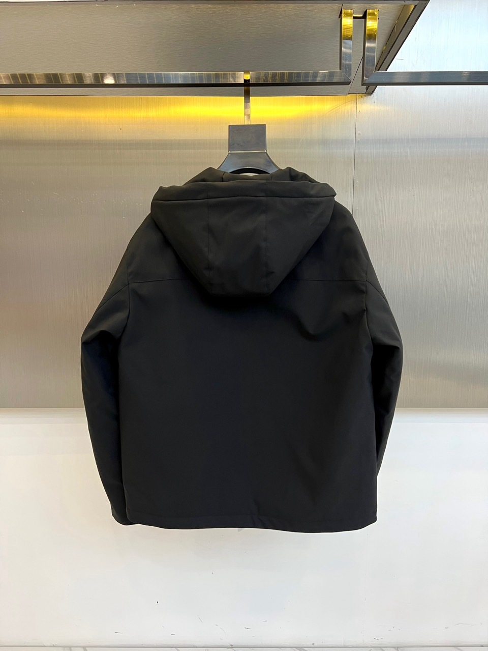 Prad普拉、2025秋冬黑色羽绒服，以品牌标志性设计语言重塑冬日型格。款式采用简约的连帽廓形，线条流畅