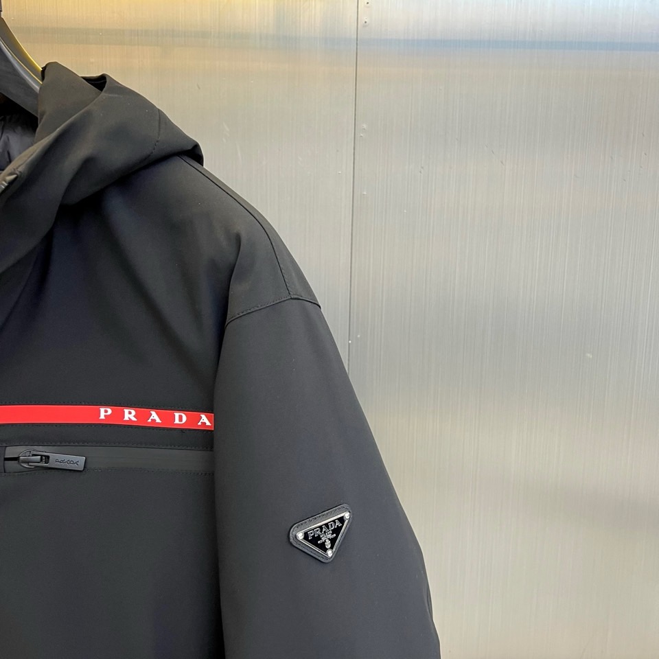 Prad普拉、2025秋冬黑色羽绒服，以品牌标志性设计语言重塑冬日型格。款式采用简约的连帽廓形，线条流畅
