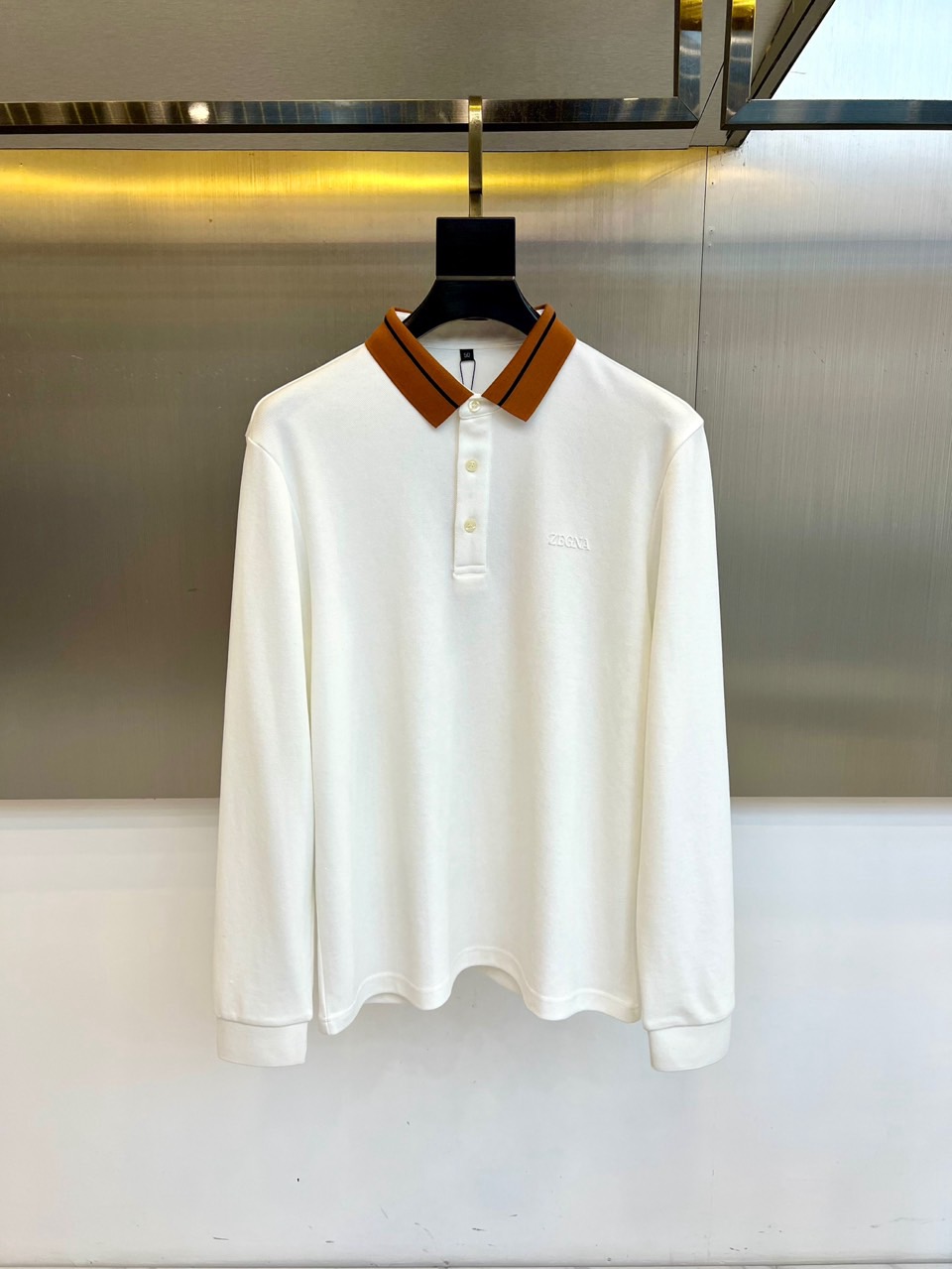 杰尼亚、2025秋冬新品男士长袖Polo衫，经典翻领设计巧妙融入棕色拼接细节，领缘点缀黑色细条纹提升精致