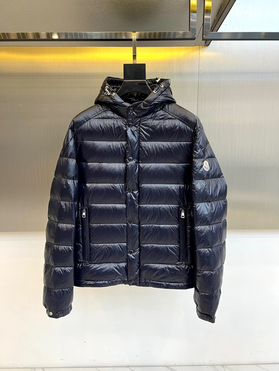 Mon蒙口（白鹅绒）、2025秋冬新品羽绒服，以深邃的色调演绎现代功能美学。款式采用连帽设计，帽檐配备可
