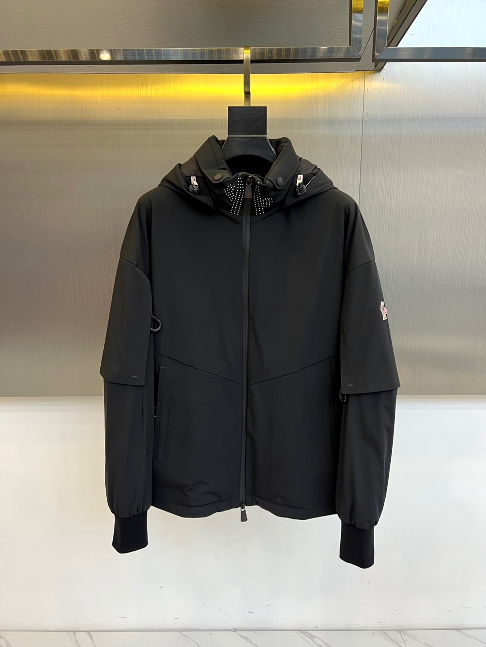 Mon蒙口（鹅绒）、2025秋冬Grenoble系列滑雪羽绒服以米白配色演绎雪场美学。连帽设计搭配黑色全