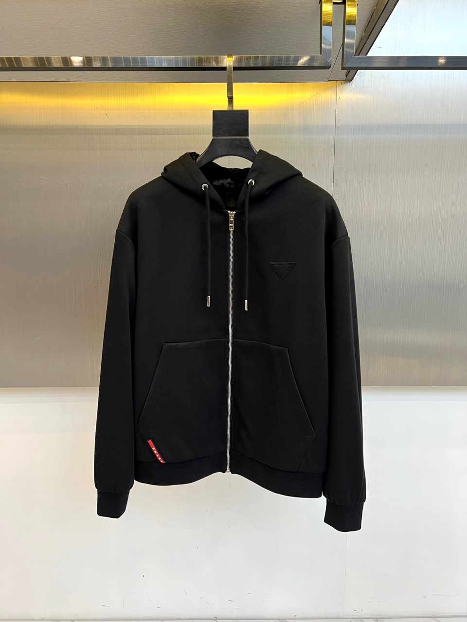 Prad普拉、2025秋冬新品连帽毛绒保暖外套，以极简主义诠释实用美学。这款外套采用立体剪裁的连帽设计，